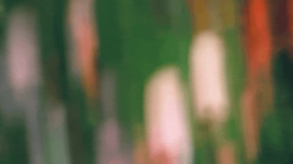 Two women sitting at a modern table talking with a city view behind them.